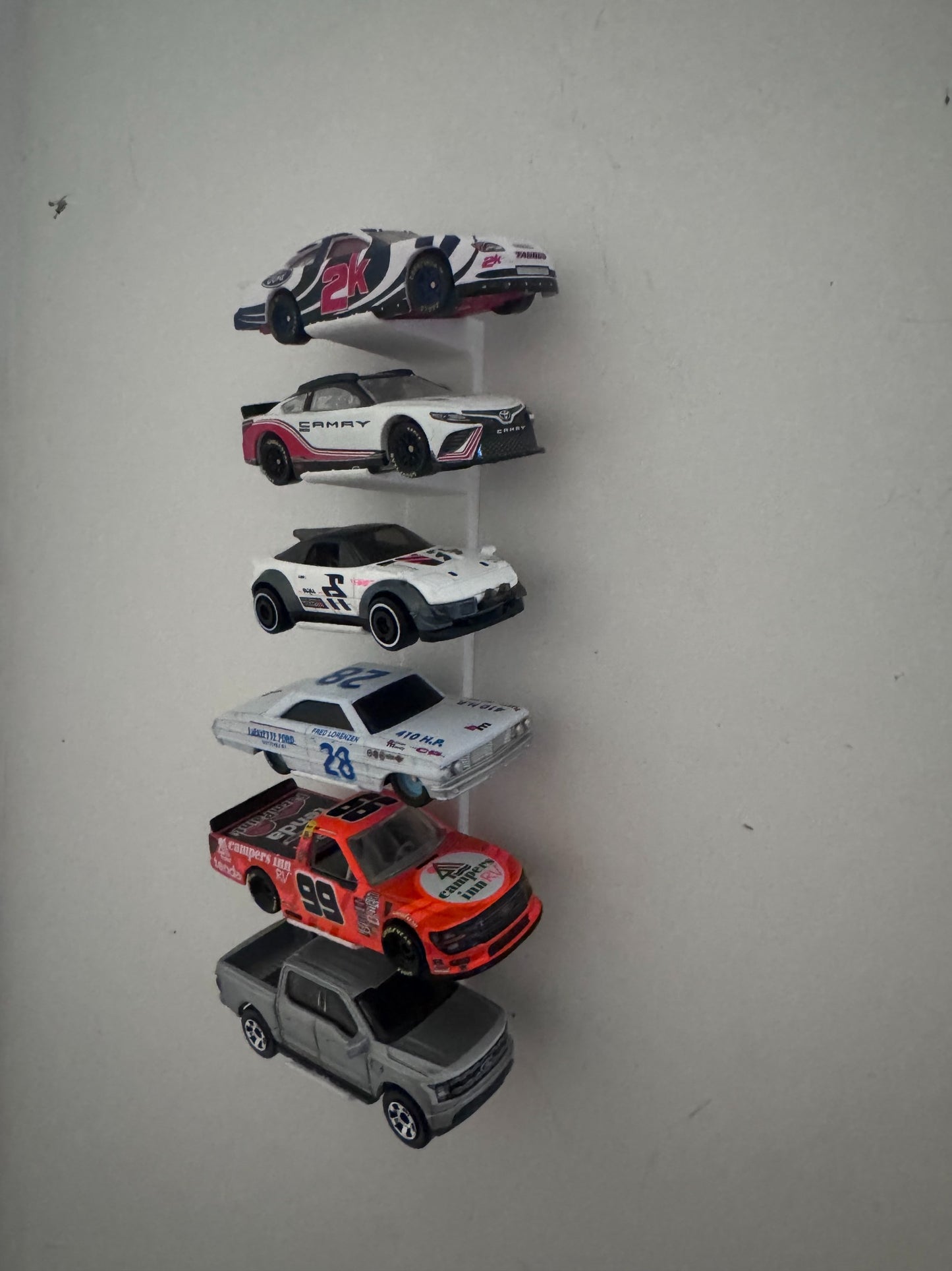 Universal floating diecast wall display holding six different 1/64 and 1/87 scale vehicles
